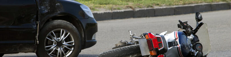 motorcycle lying in road in front of car that collided with it