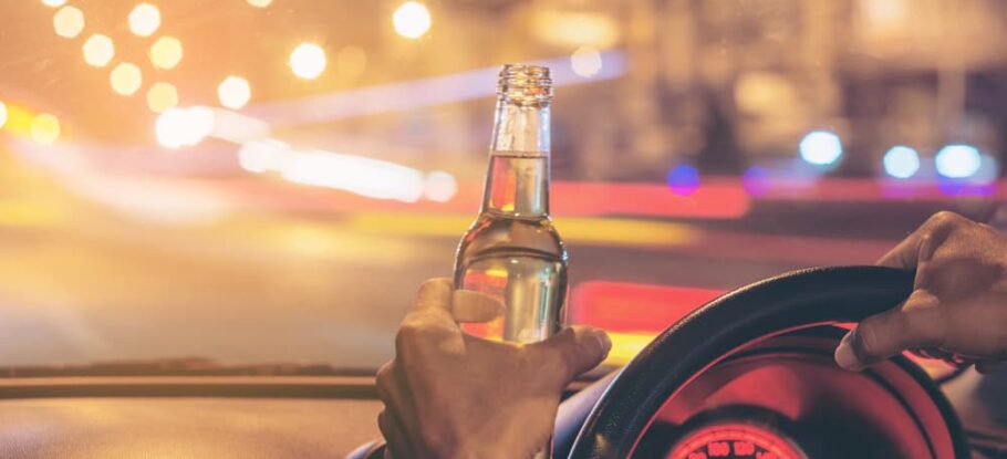 driver with open container in hand while operating the vehicle